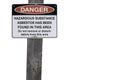 White sign on wooden post warning of asbestos danger Royalty Free Stock Photo