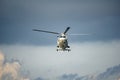 White Sikorsky S-76B helicopter fly over the sky with huge rain cloud Royalty Free Stock Photo