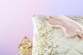 White silk pillow with pink sleep mask and golden candlestick Royalty Free Stock Photo