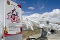 White silk scarves blow wildly next to a sign asserting Chinese government control over the people