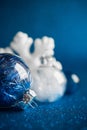 White and silver xmas ornaments on dark blue glitter background with space for text Royalty Free Stock Photo
