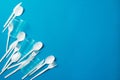 White single-use plastic knives, spoons, forks on a blue background. Say no to single use plastic. Environmental, pollution Royalty Free Stock Photo