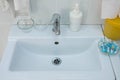 White sink in hospital room with liquid soap and medical things.