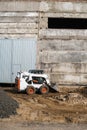 White skid steer loader at a construction site working with a soil. Industrial machinery. Industry. Royalty Free Stock Photo