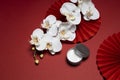 White skin care photoshoot on oriental Chinese red background with paper art and asian flower