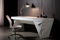 a white, sleek desk with a modern chair and laptop on it