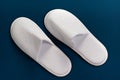 White slippers on a blue background. Slippers for guests. Slippers Royalty Free Stock Photo