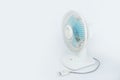 White small fan with blue blade againts white background