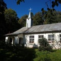 White small Old fashioned country church in rural area under blue sky Royalty Free Stock Photo