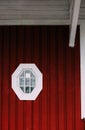 White small window on the red wall of the old wooden building Royalty Free Stock Photo