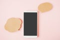 White smart phone with clipping path on touchscreen , couple of blank grunge brown bubble speech paper on sweet pink background