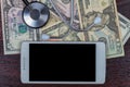 White smartphone along with American dollar bills and a stethoscope