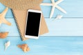 White smartphone on brown notebook on blue wooden floor,Flat lay photo of technology concept in summer