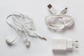 White smartphone charger, USB Cable and white earphones on a white background. Royalty Free Stock Photo