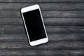 White smartphone on grey wooden background. Personal device mockup
