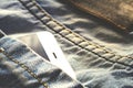 White smartphone lies in blue jeans