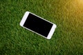White smartphone with screen on fake grass