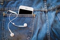 White smartphone in your pocket blue jeans with earphone Royalty Free Stock Photo