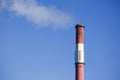 White smoke from the boiler room chimney against the blue sky. Royalty Free Stock Photo