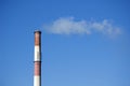 White smoke from the boiler room chimney against the blue sky. Royalty Free Stock Photo