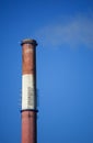 White smoke from the boiler room chimney against the blue sky. Royalty Free Stock Photo