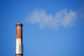 White smoke from the boiler room chimney against the blue sky. Royalty Free Stock Photo