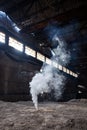 white smoke bomb in deserted factory interior