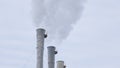 White smoke comes out in horrific clouds from old chimney of factory plant or power plant, polluting environment. Toxic