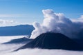 White smoke coming out of volcanoes surrounded by white clouds of mist.