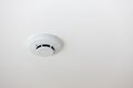 White smoke detector on ceiling. Fire smoke sensor on ceiling. Ceiling white fire detector used to activate warning systems in bui Royalty Free Stock Photo