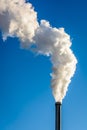 White smoke escaping from a metallic chimney against blue sky