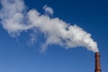 White smoke from the factory brick chimney. Blue sky. Ecology and production. Copy space Royalty Free Stock Photo