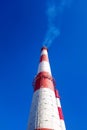 White smoke from the factory brick chimney. Ecology and production. Blue sky. Copy space. Vertical view. Royalty Free Stock Photo