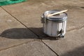 A white snare drum, a marching band instrument placed on the outdoor street floor.