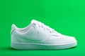 white sneaker Nike on green background. Fashionable stylish leather sports casual shoes