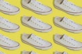 White sneakers pattern. Sports casual shoes on a yellow background. Royalty Free Stock Photo