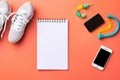 White sneakers, smartphone, earphones and notebook on orange background, Sports equipment with shoes, skipping rope, blank