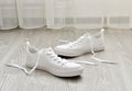 White sneakers with untied laces are on floor Royalty Free Stock Photo