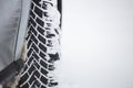 White snow on car` s wheel tire, snowy background, copy space