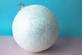 White snow small round xmas festive Christmas ball, Christmas toy plastered over sparkles on a pink purple blue background Royalty Free Stock Photo