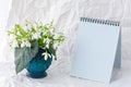 White snowdrops Galanthus nivalis in a vase on a white background and with a notepad for text Royalty Free Stock Photo