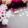 White snowflake on background of magenta and gold xmas baubles. Royalty Free Stock Photo