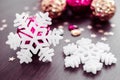 White snowflakes on background of magenta and gold xmas baubles. Royalty Free Stock Photo