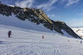 White snowy ski slopes and people skiing. Snowy winter mountain background. Royalty Free Stock Photo