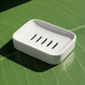 White soap dish with a rectangular shape sits on a green surface. It features a Royalty Free Stock Photo