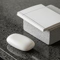 White soap rests on a polished black granite surface, next to a Royalty Free Stock Photo