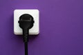 white socket and black plug  on purple background Royalty Free Stock Photo