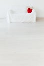 White sofa with a red pillow in the interior of the white room Royalty Free Stock Photo