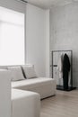 White sofa in room with hanging garment rack