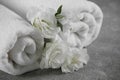 White soft towels with flowers on grey table, closeup Royalty Free Stock Photo